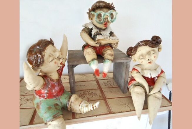 Bild vergrößern: Drei sitzend gestaltete Keramikfiguren der Kunsthandwerkerin Anke Rehfeldt, die ihre Produkte auf dem 10. Hennigsdorfer Kunsthandwerkermarkt 2022 anbietet.
